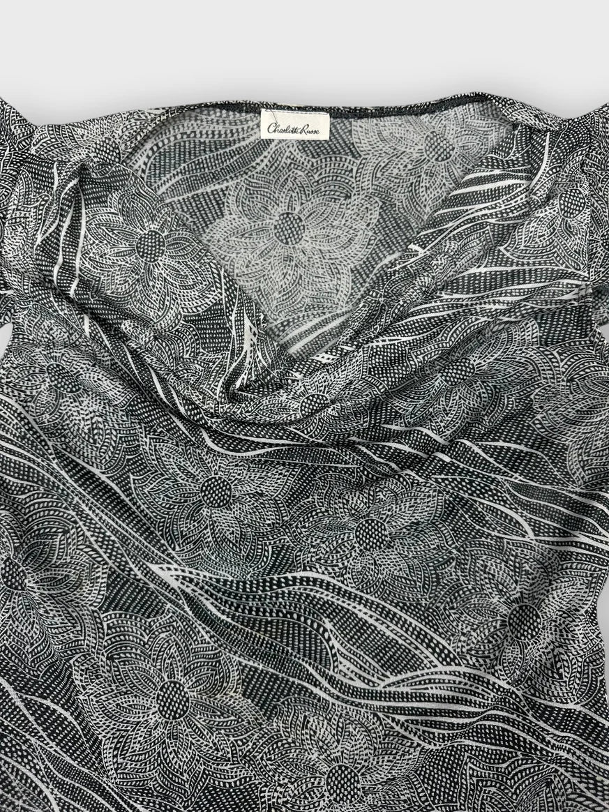 Detail view of a gray short sleeve top with floral pattern.