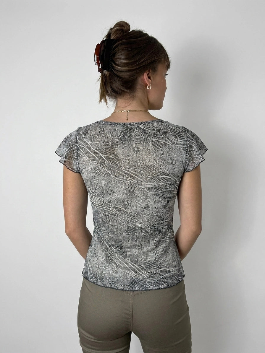 Back view of a chic short sleeve top in gray with flowing wave patterns.