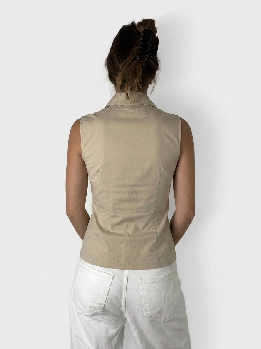 Back view of a beige sleeveless top with a sharp collar.
