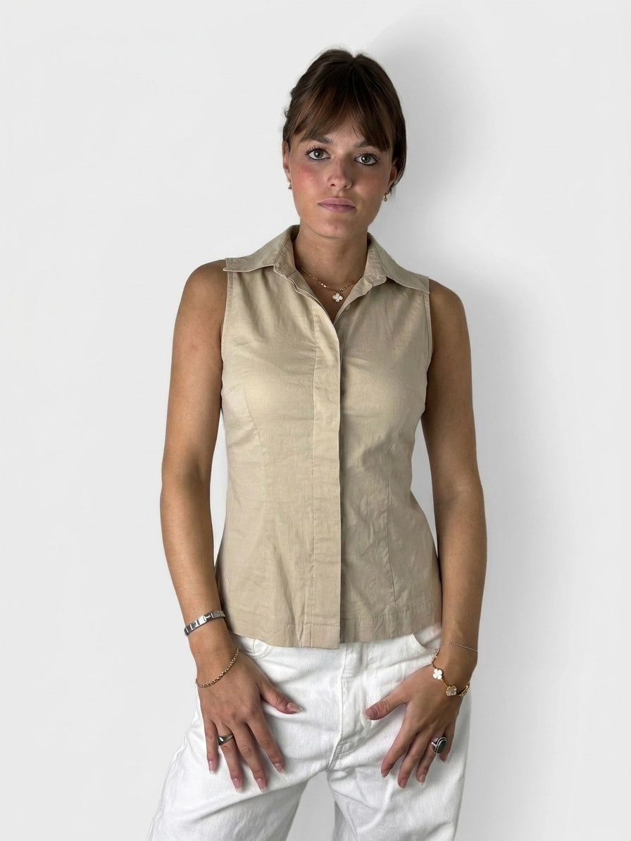 Chic sleeveless top in beige with sharp collar, front view.