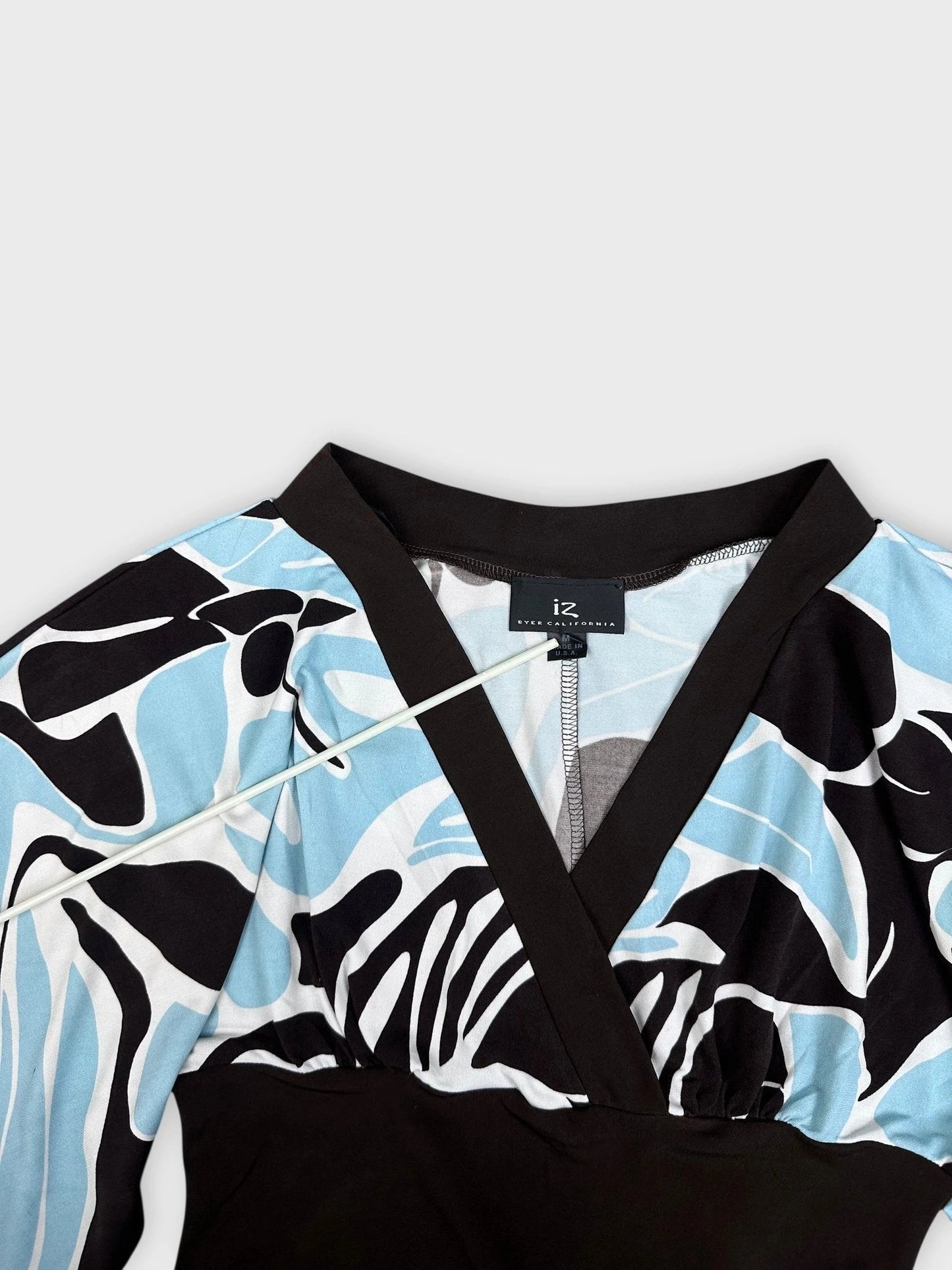 Detail view of chic kimono top featuring blue swirl print and black contrast trim.