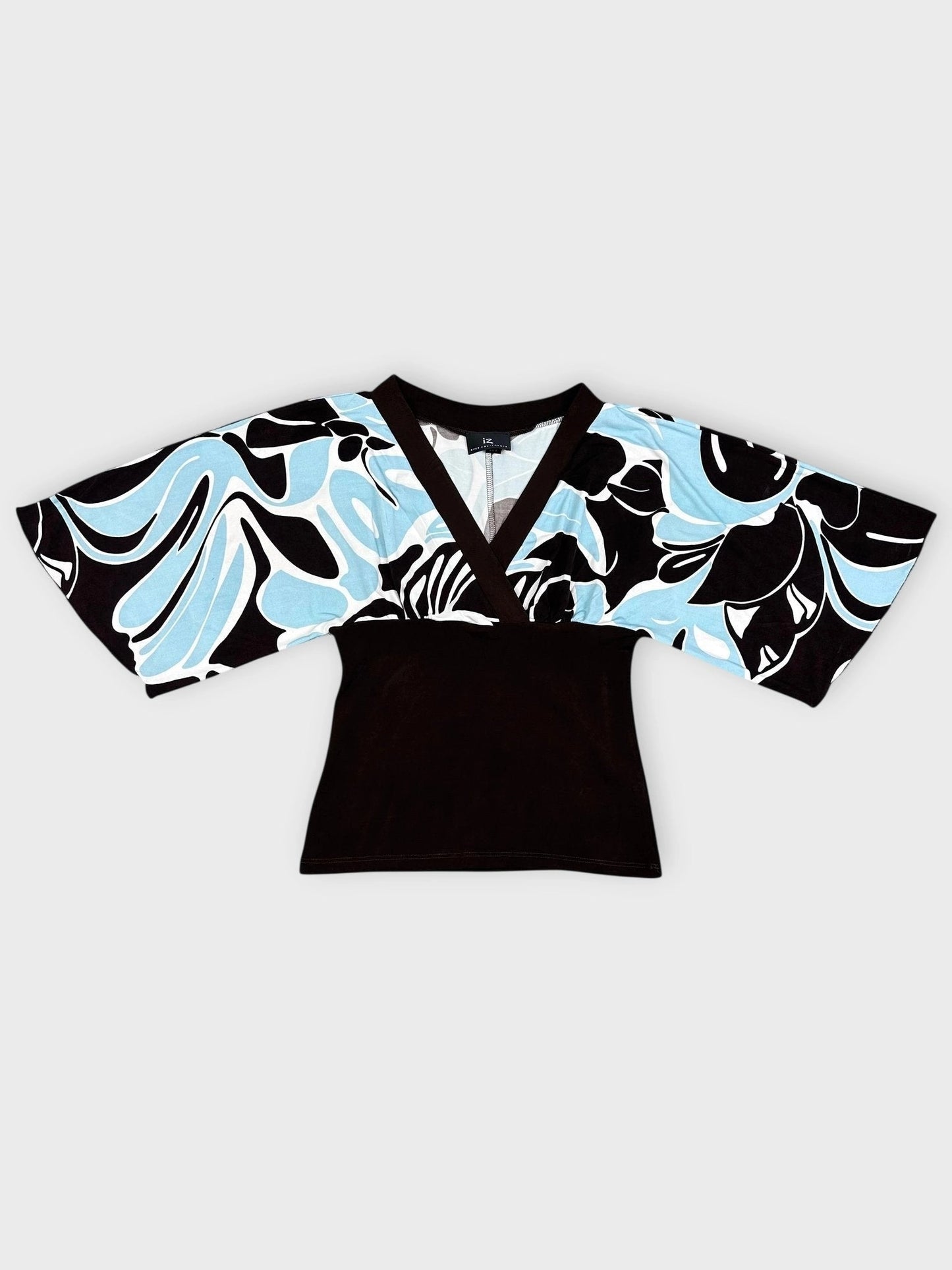 Detail view of a kimono top featuring a black and white swirl print with blue accents.