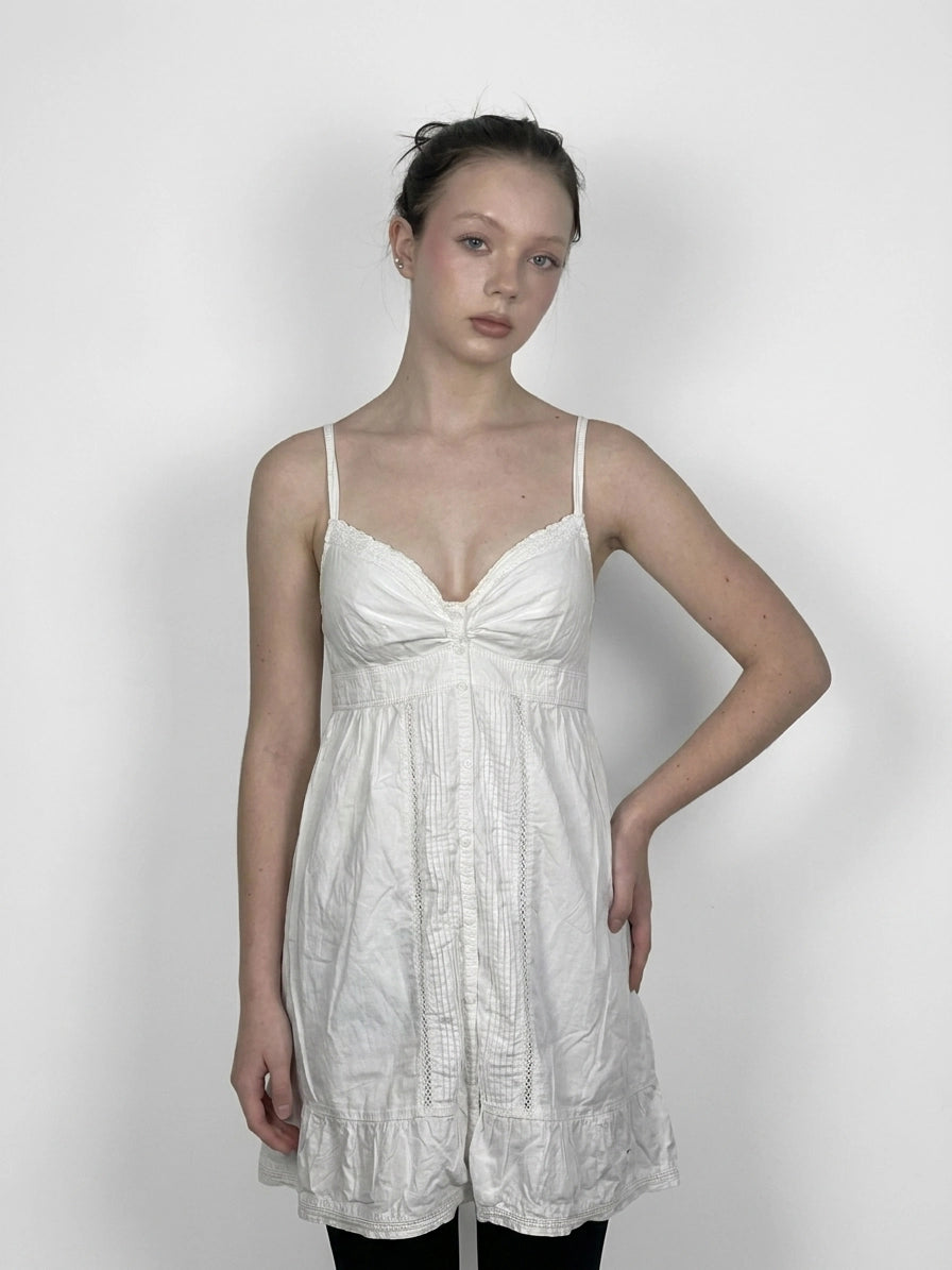 Chic white cotton strap dress with lace trim, front view.