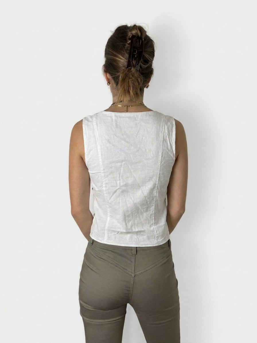 Back view of a white linen top featuring a lace-up detail.