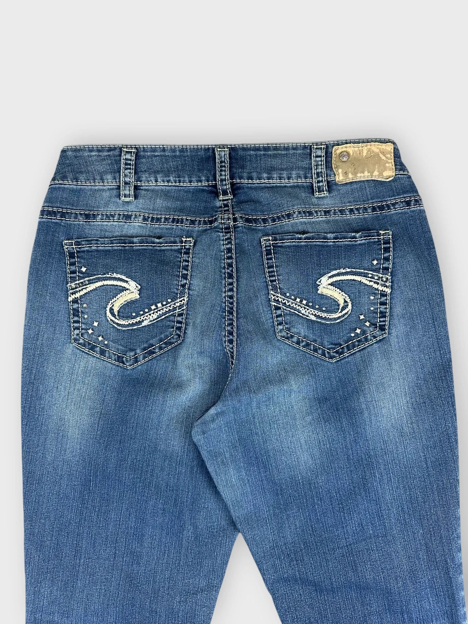 Back view of blue denim jeans featuring decorative stitching on pockets.