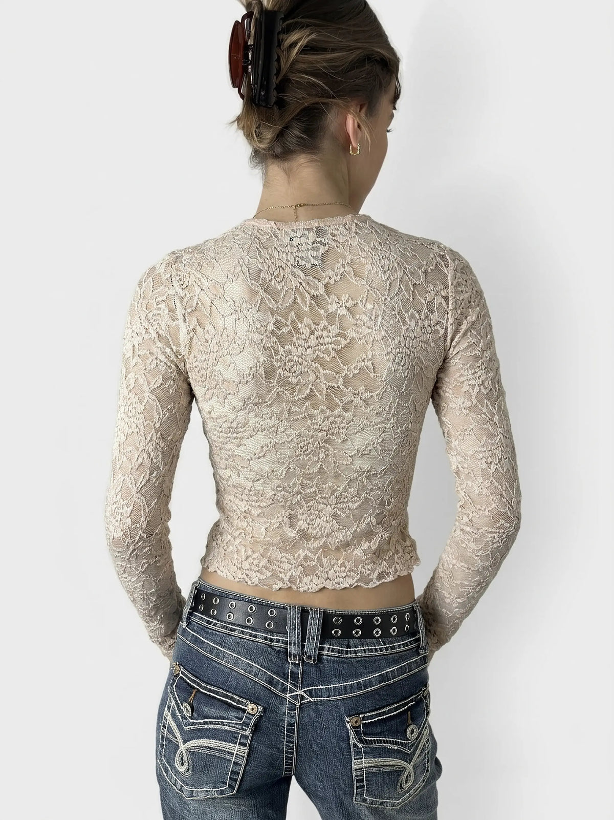 Back view of cream lace crop top featuring sheer details.