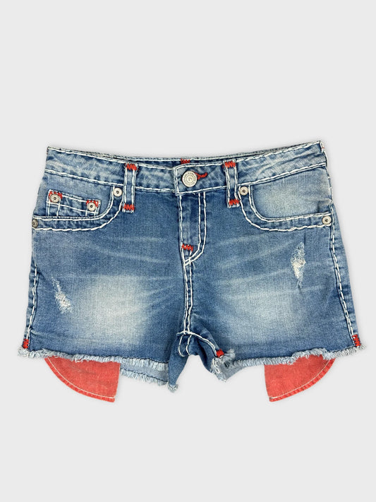 Front view of blue denim shorts with edgy red stitching and frayed hem.