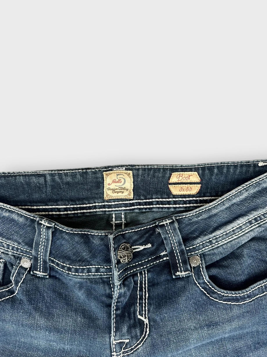 Detail view of flared jeans in dark wash featuring classic pockets and contrast stitching.