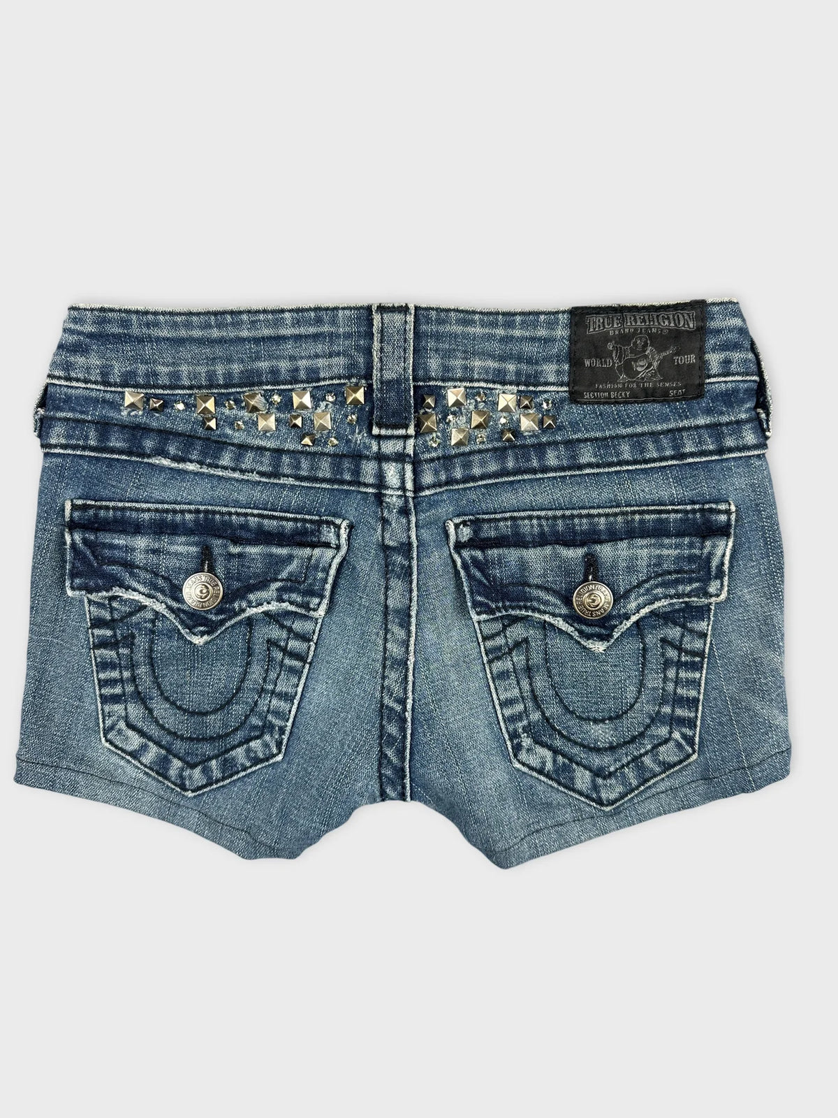 Back view of edgy denim shorts in blue with studded details.