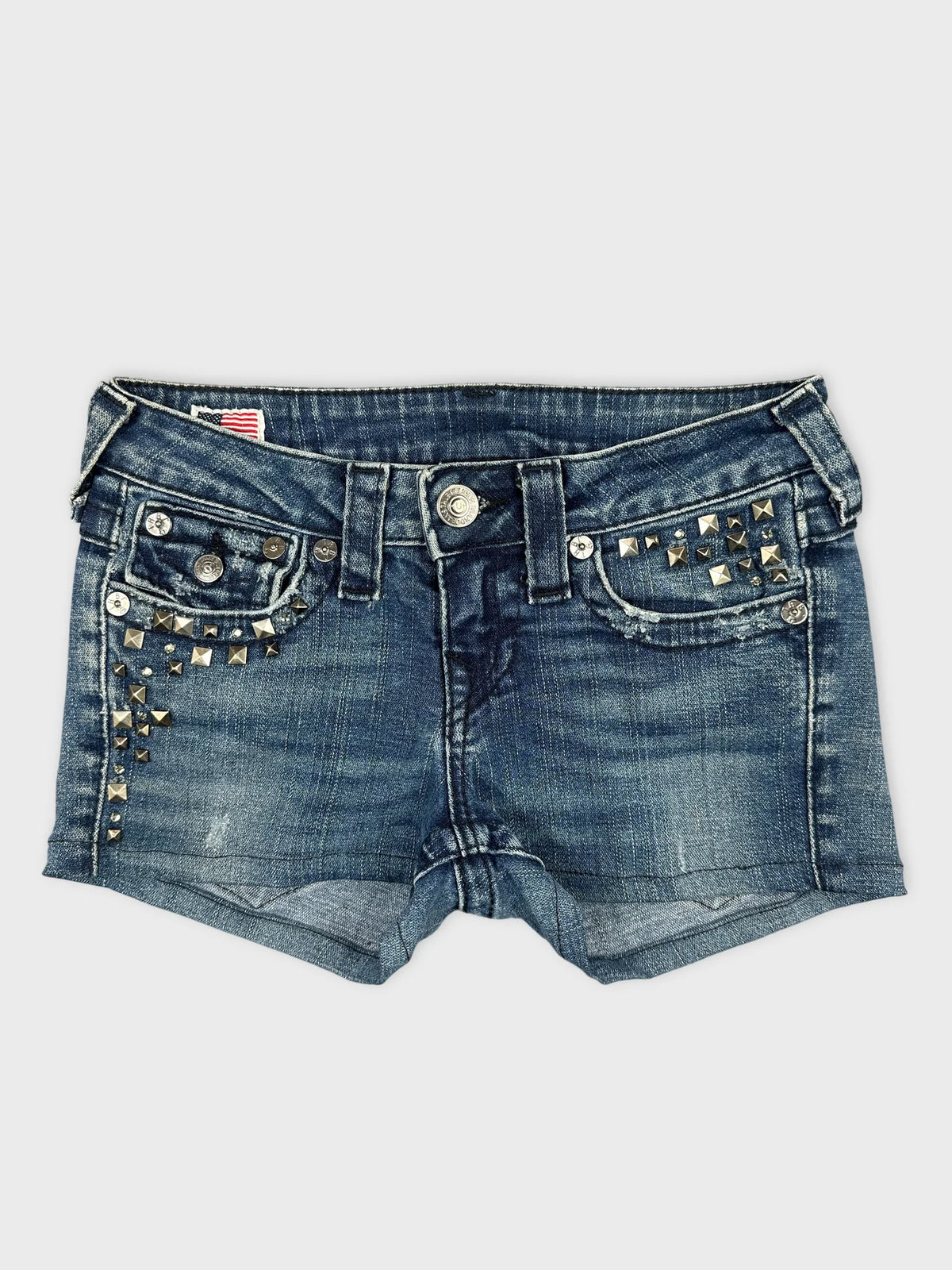 Front view of edgy denim shorts in dark blue with studded details.