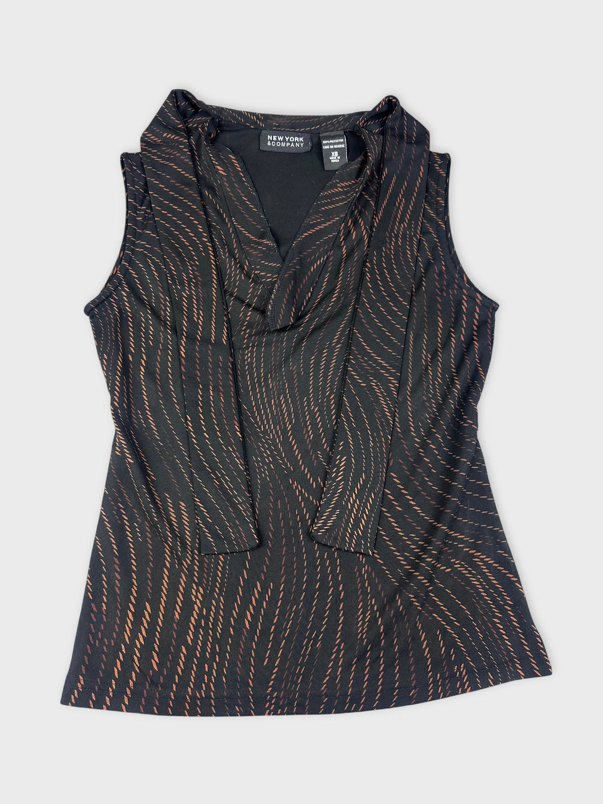 Detail view of an elegant black cowl neck top with wavy orange pattern.