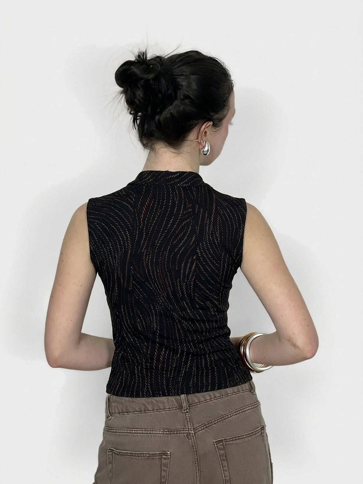 Back view of elegant black cowl neck top featuring subtle orange wave pattern.