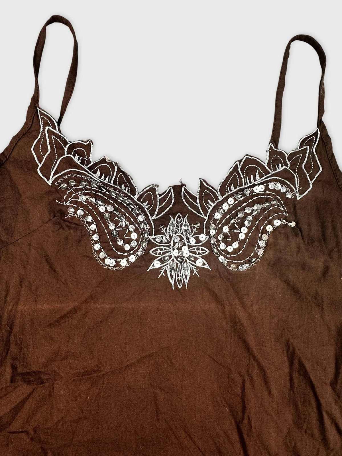 Detail view of brown cami top with embroidered floral design and embellishments