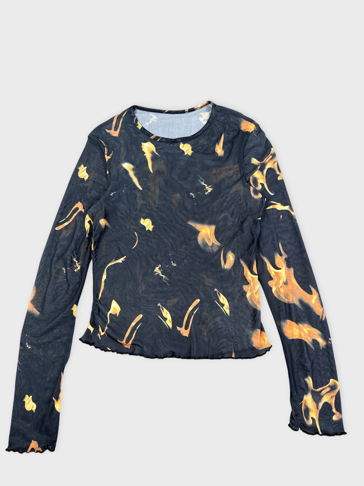 Detail view of a flame-print graphic top in black with vibrant orange flames.