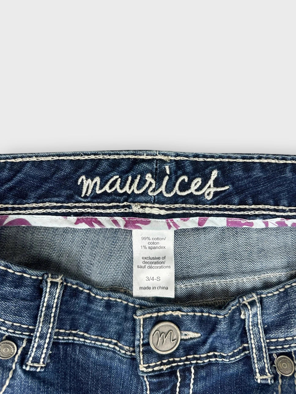detail view of flared denim jeans featuring a distressed detail and blue color