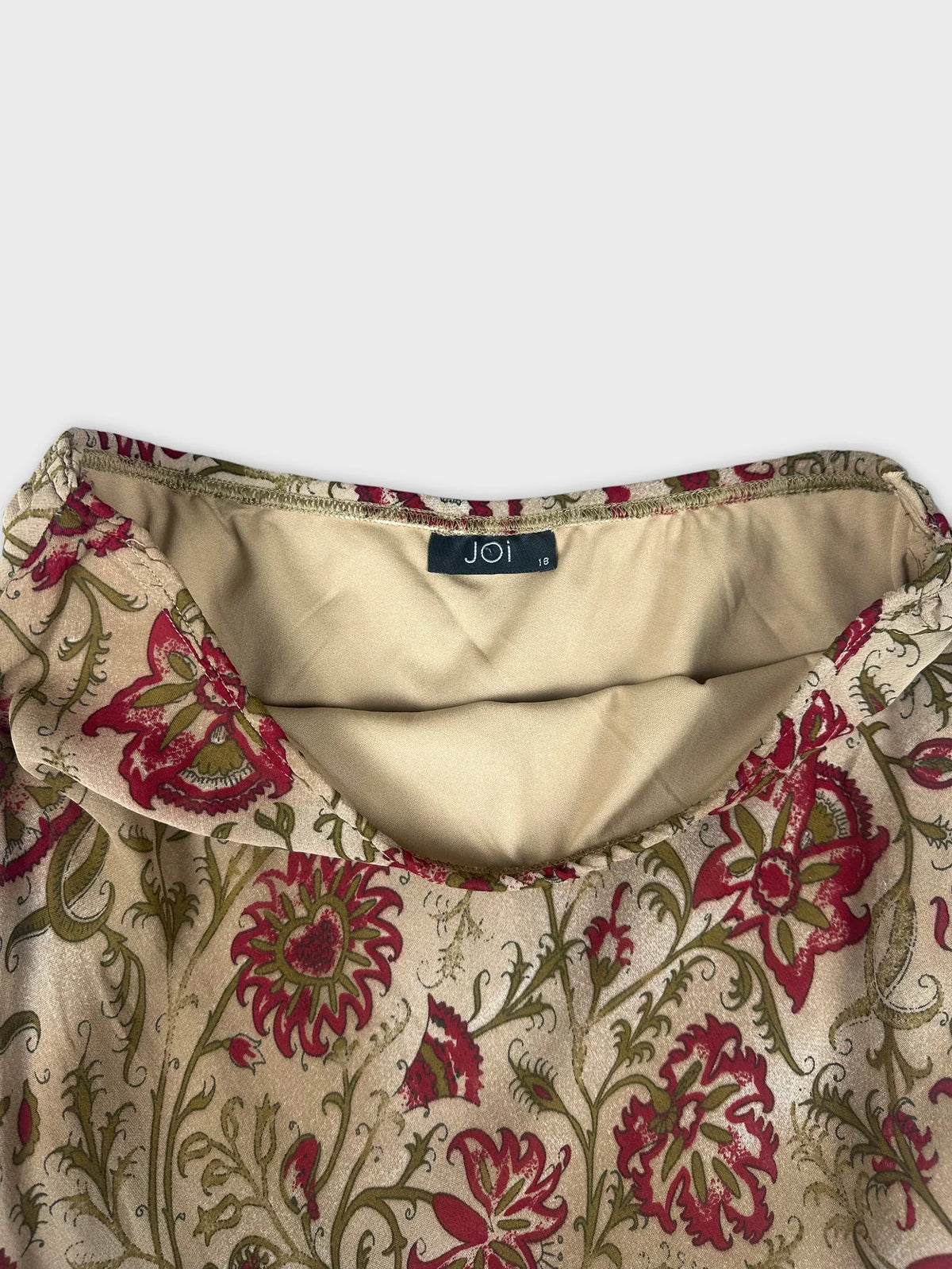 Detail view of floral maxi skirt featuring a beige background and red floral print.
