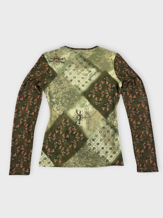 Back view of a long sleeve top in green with floral patchwork design.