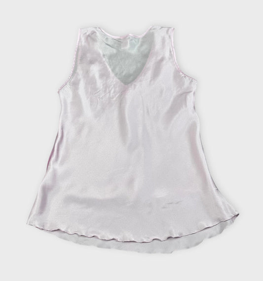 Back view of a sleeveless pink silk top featuring a V-neck and soft drape.