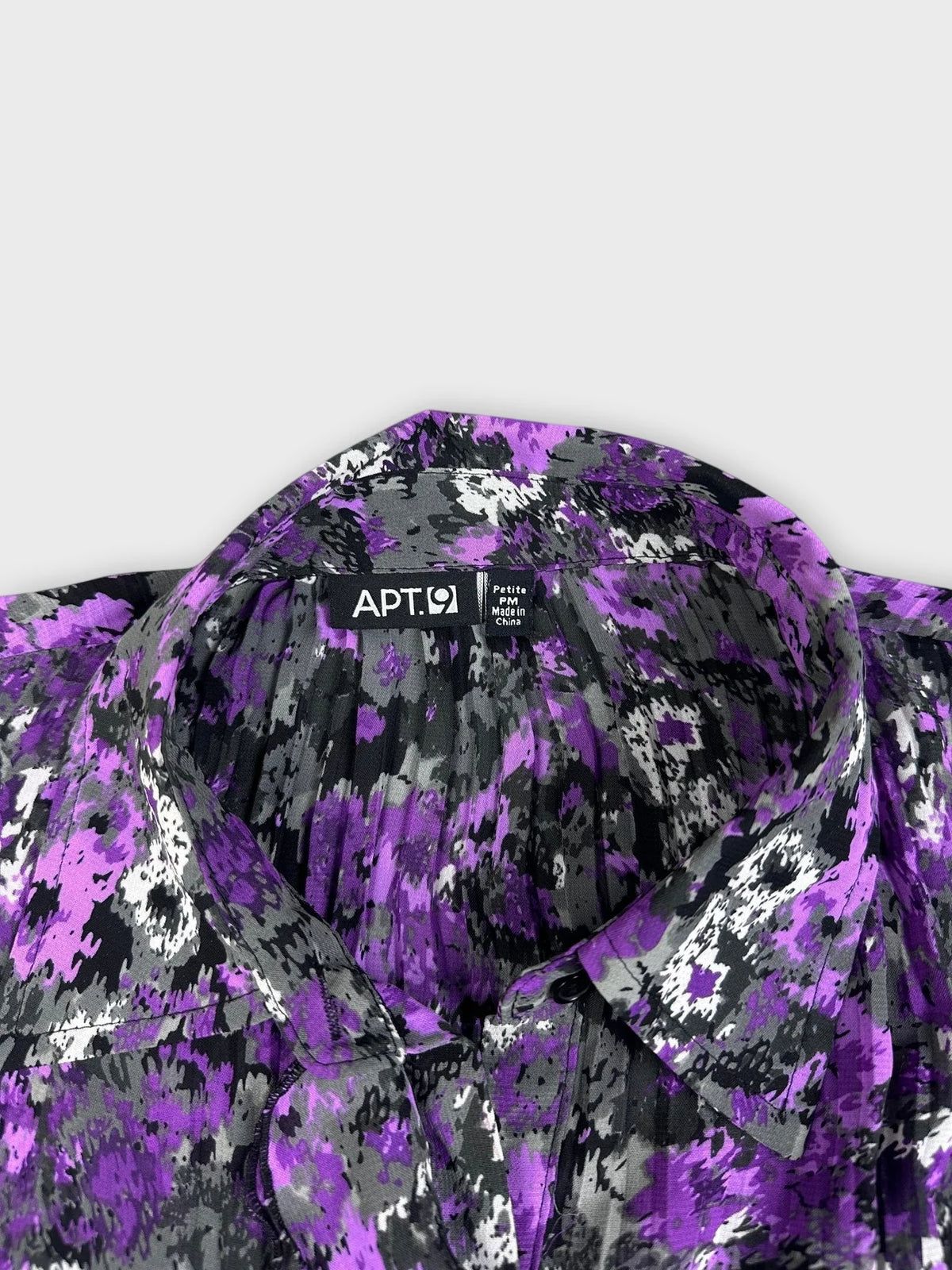 Floral ruffle blouse in purple detail view with bell sleeves and bold print.