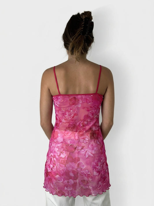 Back view of a sheer pink top with floral print and adjustable straps.