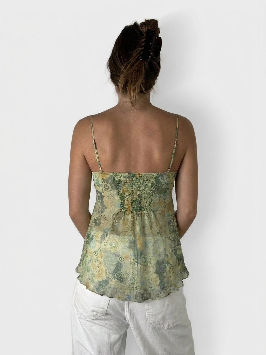 Back view of a green floral silk cami top with adjustable straps.
