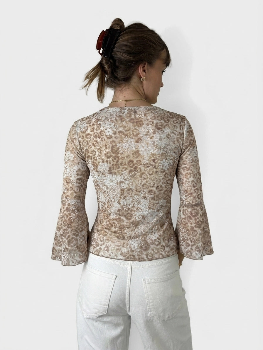 Back view of a floral V-neck bell sleeve top in beige with lace detail.