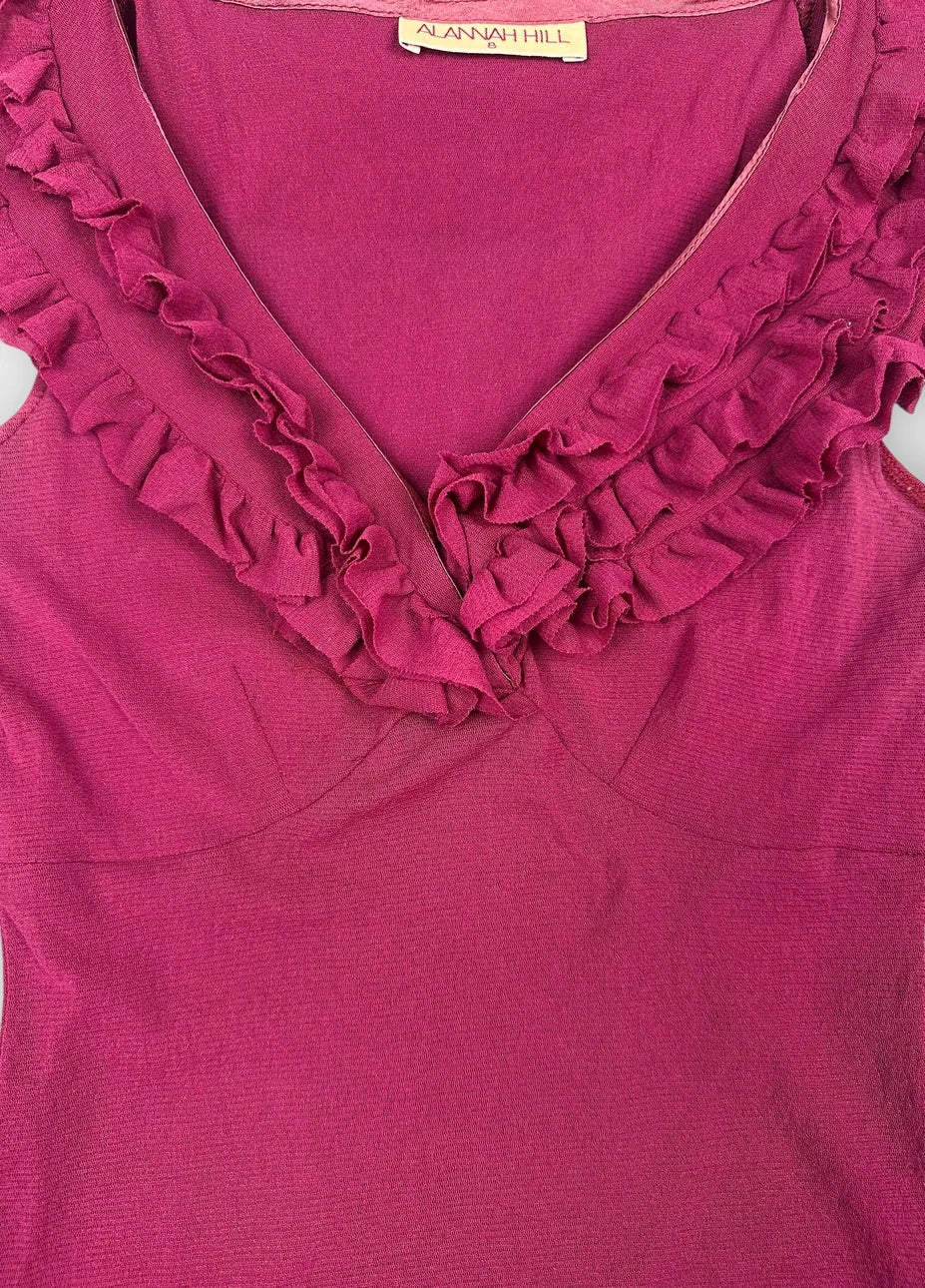 Detail view of a fuchsia ruffled top featuring a V-neckline.