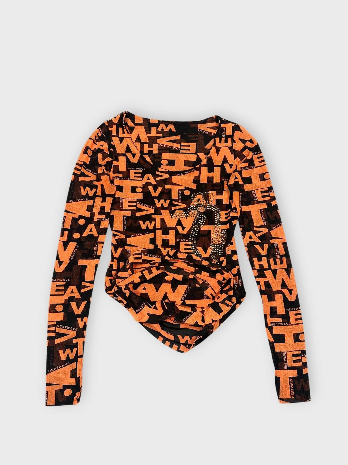 Detail view of a long sleeve top in bold orange featuring black graphic prints.