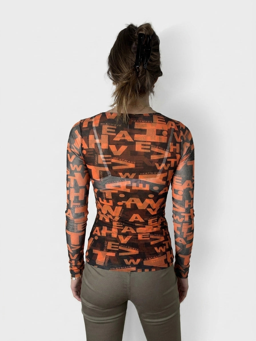 Back view of a graphic long sleeve top in bold orange with text print.