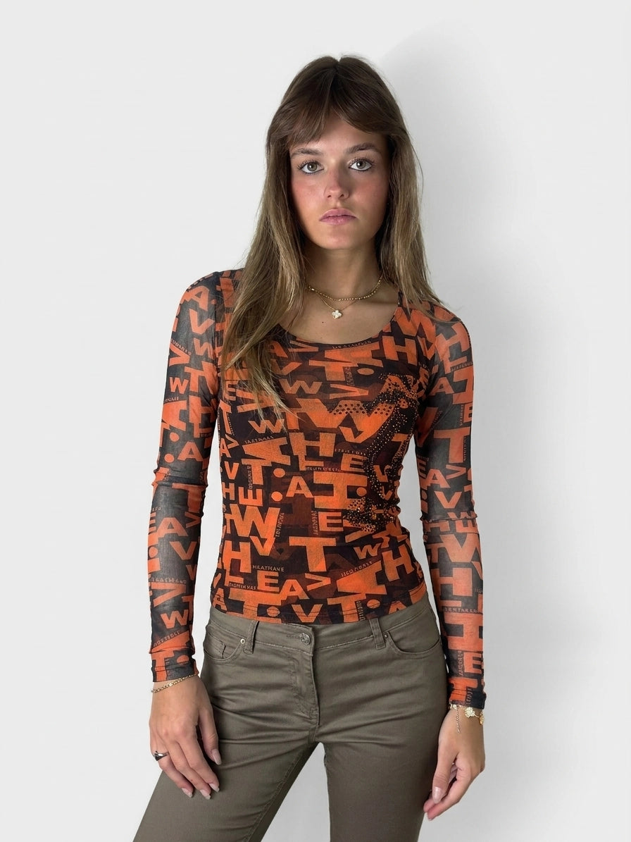Front view of a long sleeve top in bold orange with graphic print.