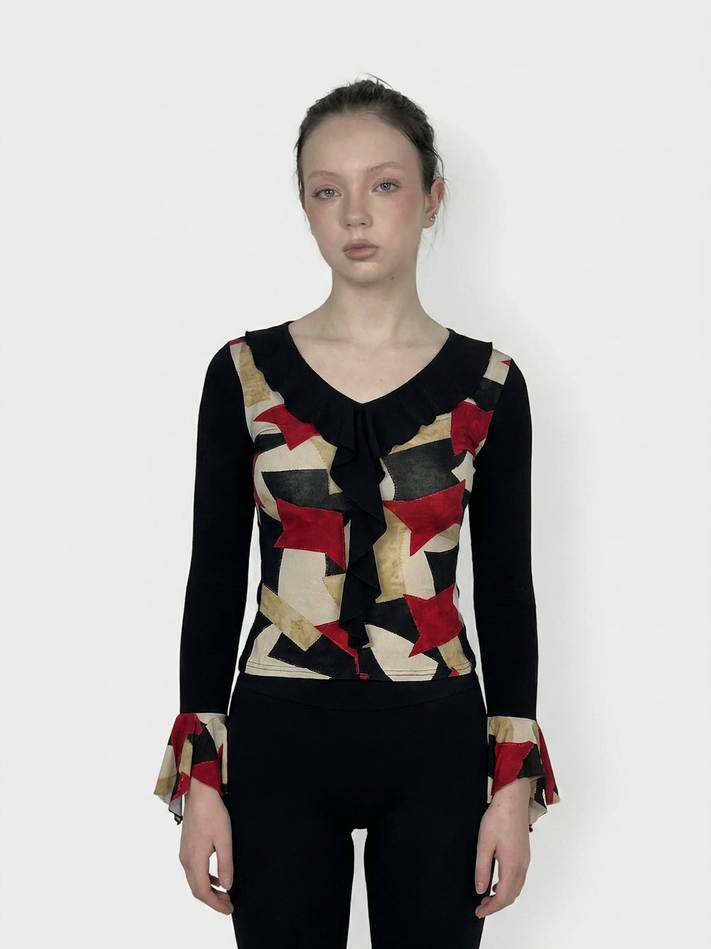 Front view of a graphic print body shirt in black, featuring red and gold pattern and flare sleeves.