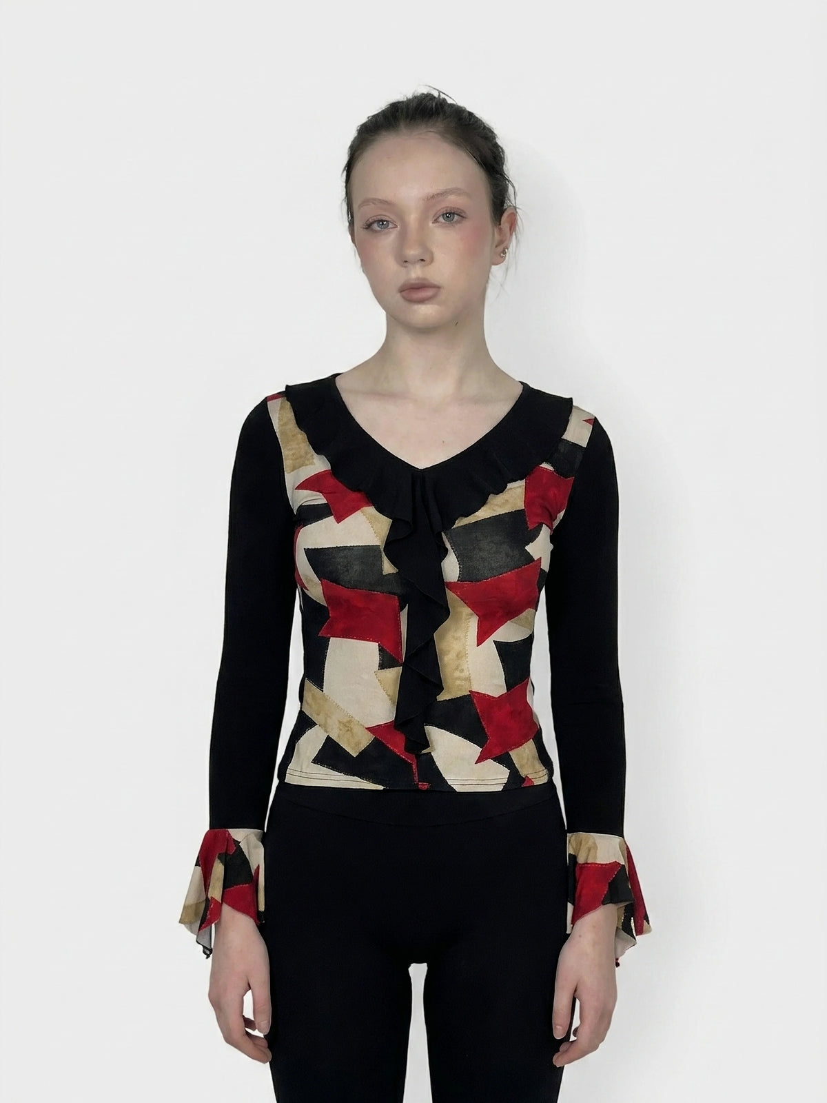 Front view of a graphic print body shirt in black, featuring red and gold pattern and flare sleeves.
