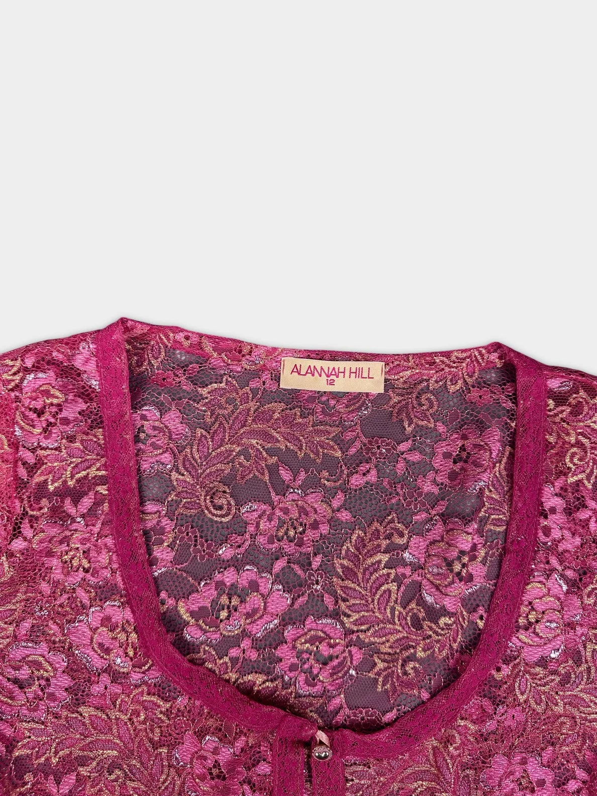 Detail view of a lace button-up top in deep red with floral pattern.