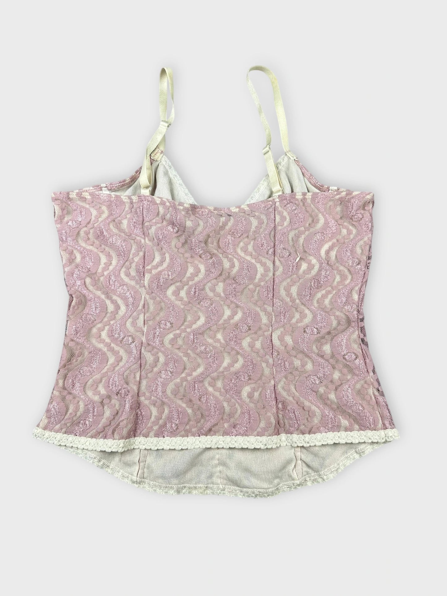 Back view of a lace pink crop top with wavy pattern and scalloped trim.