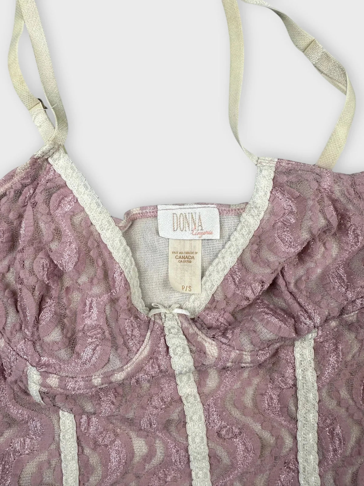 Detail view of lace pink crop top with sweetheart neckline and scalloped trim.