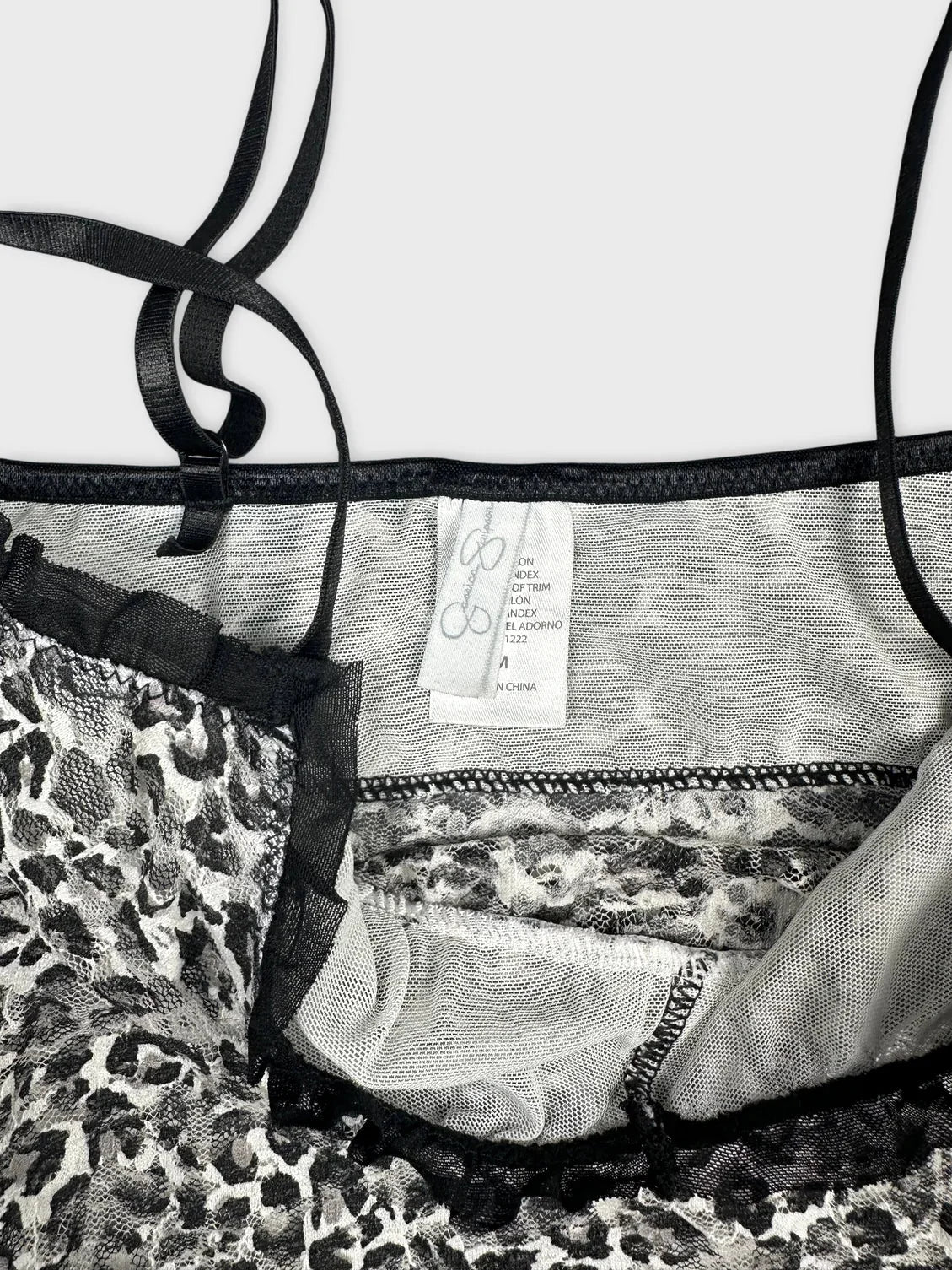 Detail view of leopard print flare top featuring ruffles and black trim.