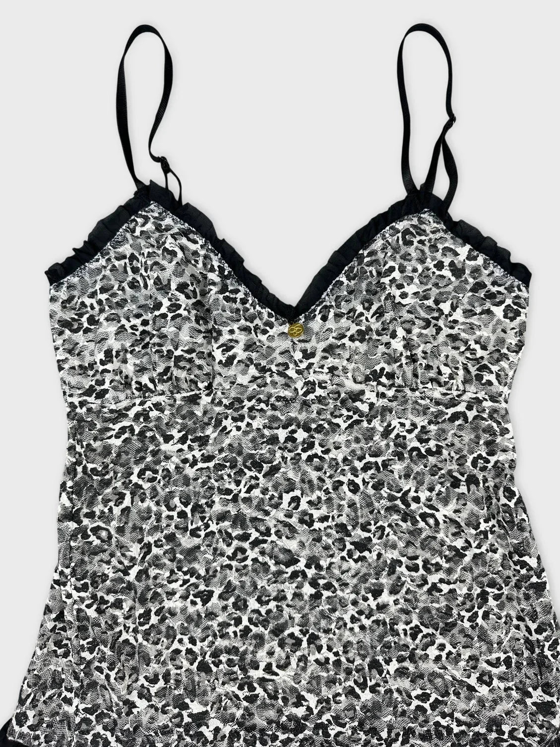 Detail view of a black and white leopard print flare top with ruffles.