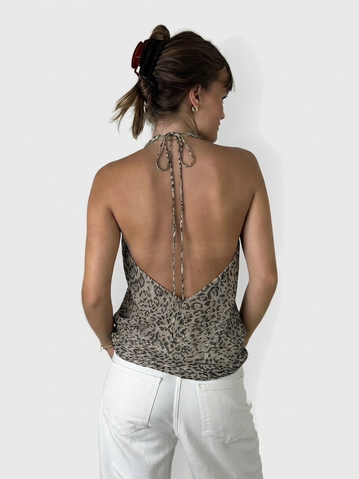 Back view of a leopard print silk halter top with a low cut.