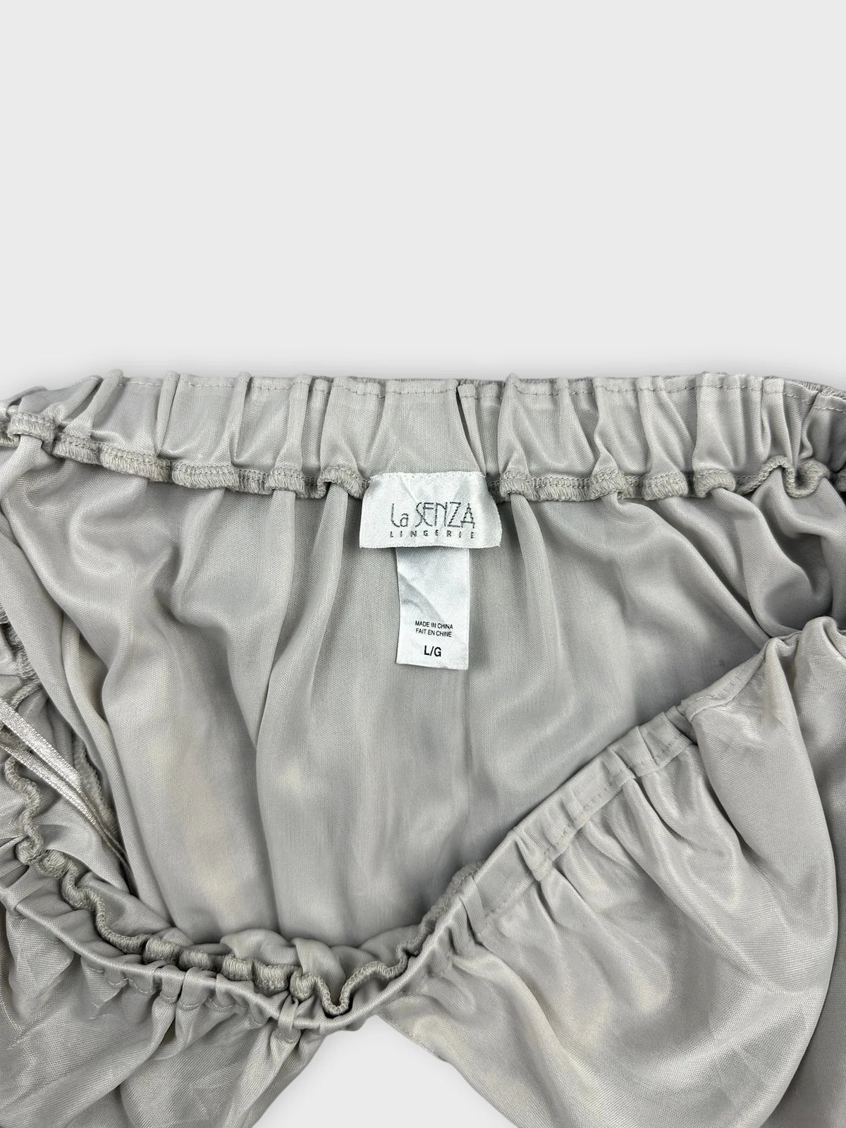 Light grey silk halter top detail view showcasing delicate elastic trim.