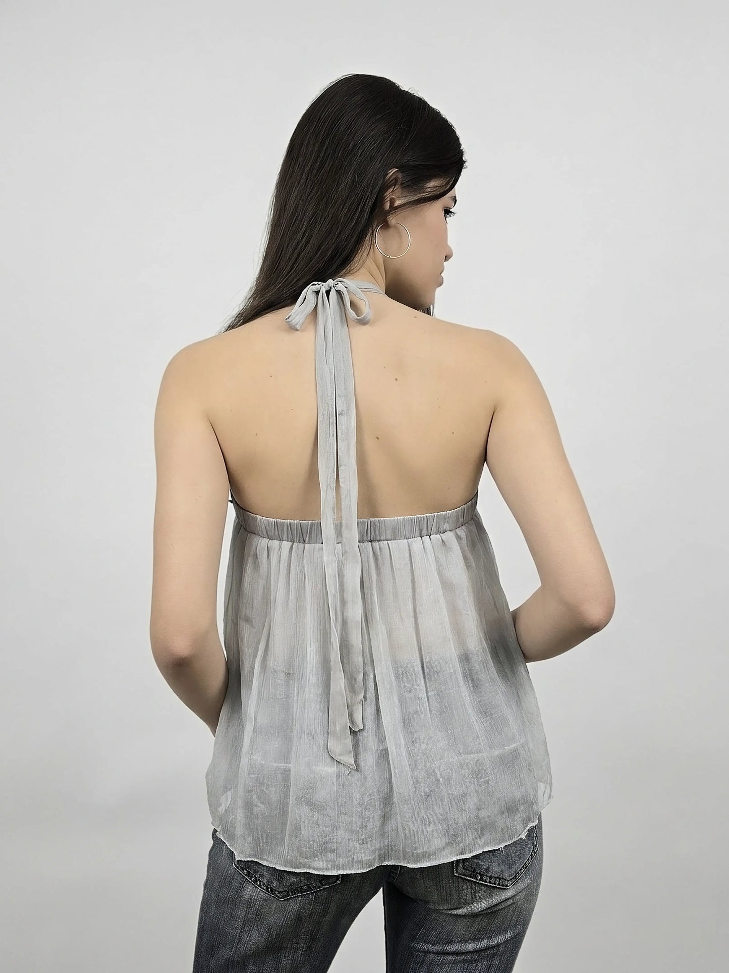 Back view of light grey silk halter top with flowing fit and tie detail.