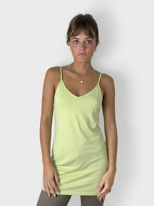 Front view of a lime green slip dress featuring adjustable straps.