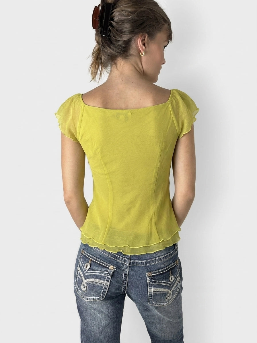 Back view of lime puff sleeve top featuring a scalloped hem.