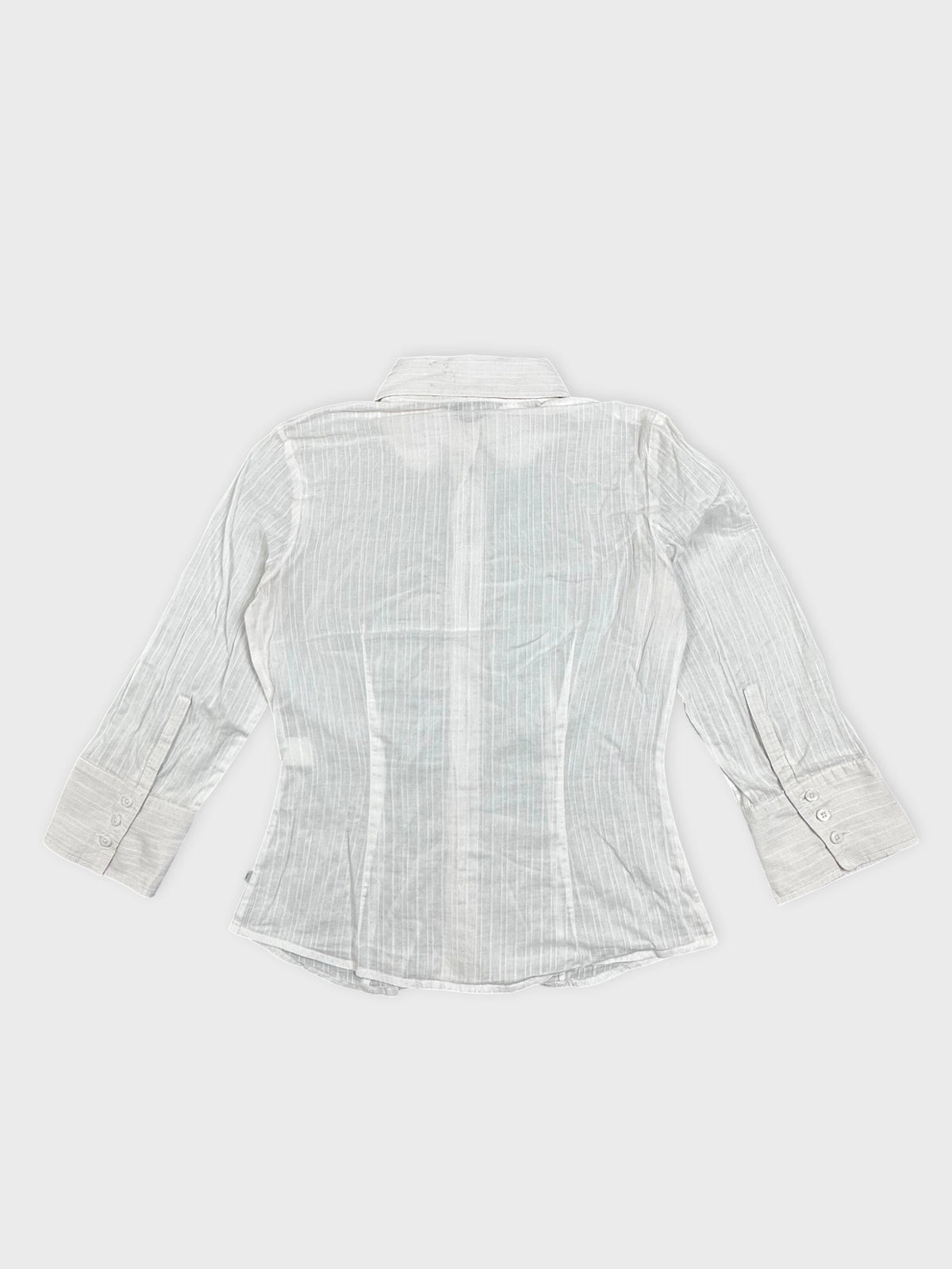 Back view of a white shirt featuring vertical stripes and buttoned cuffs.