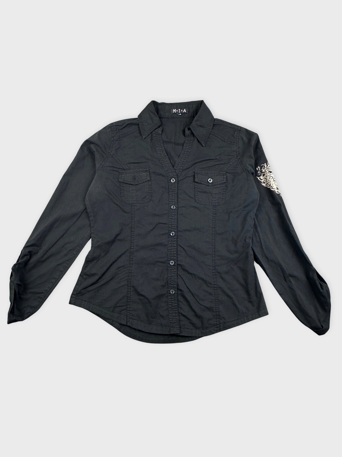 Detail view of a long-sleeve black blouse with embroidered sleeve design.