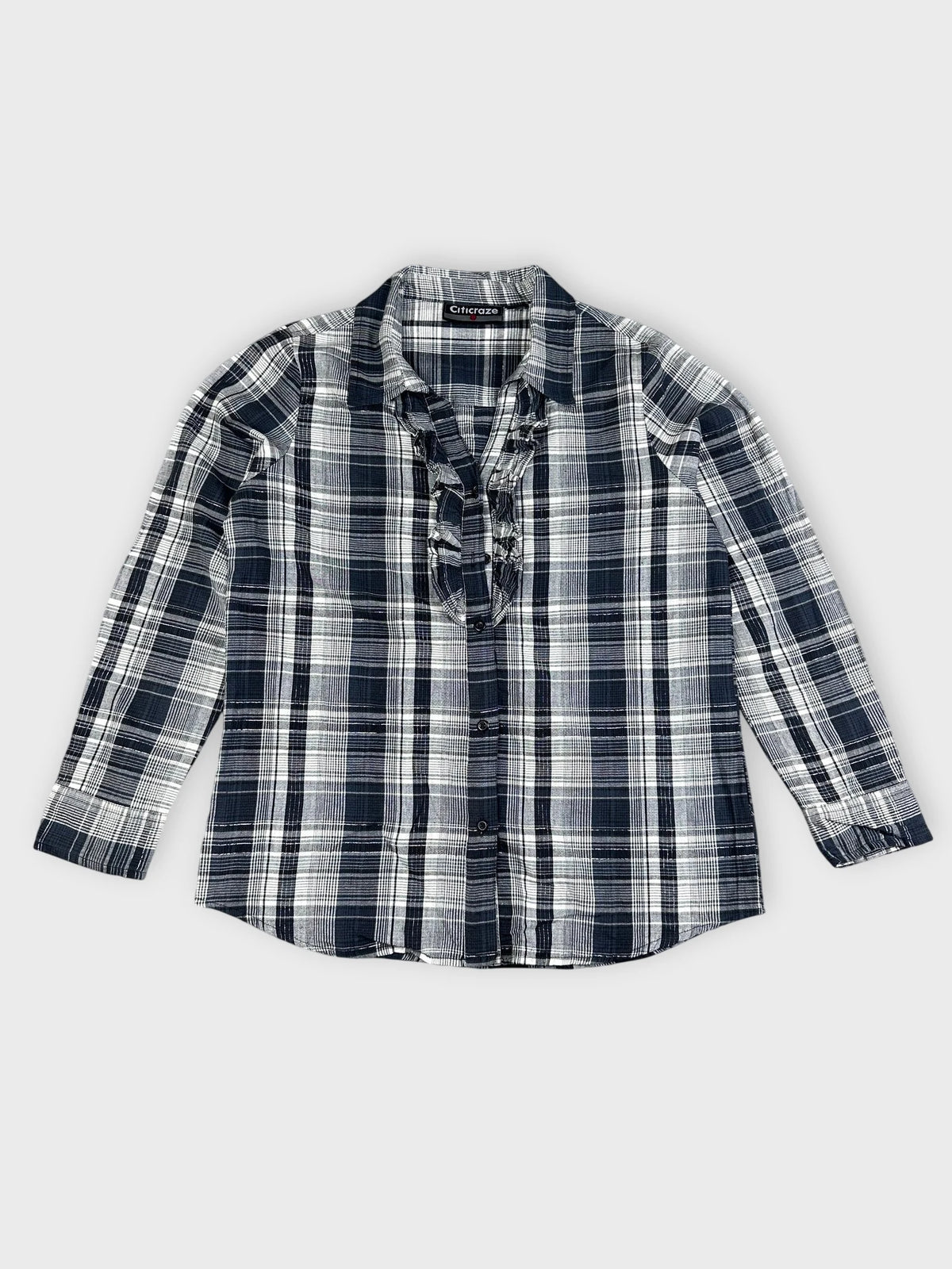Front view of a longsleeve top in navy and white plaid pattern.