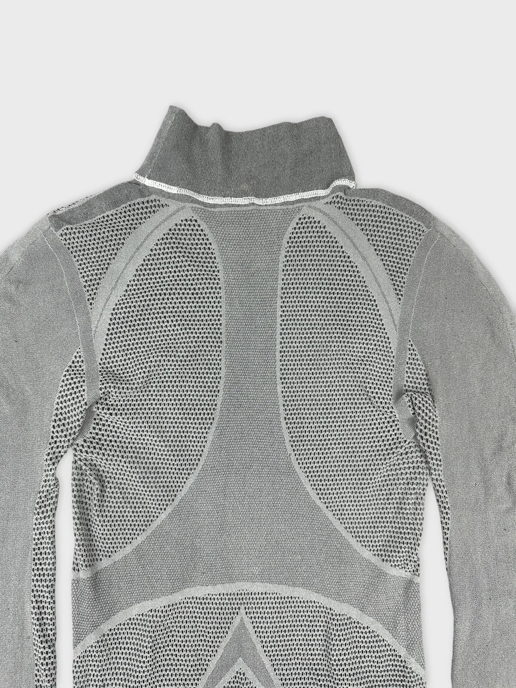 Detail view of gray mesh long sleeve top with high collar and textured pattern.