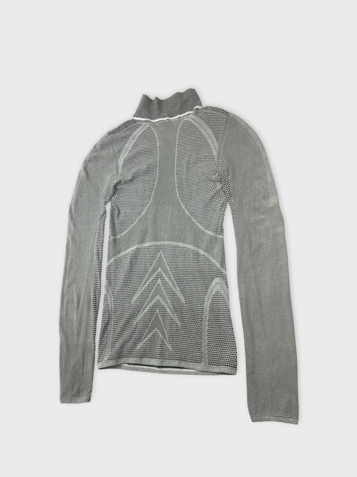 Detail view of gray mesh long sleeve top with bold patterns and high collar.