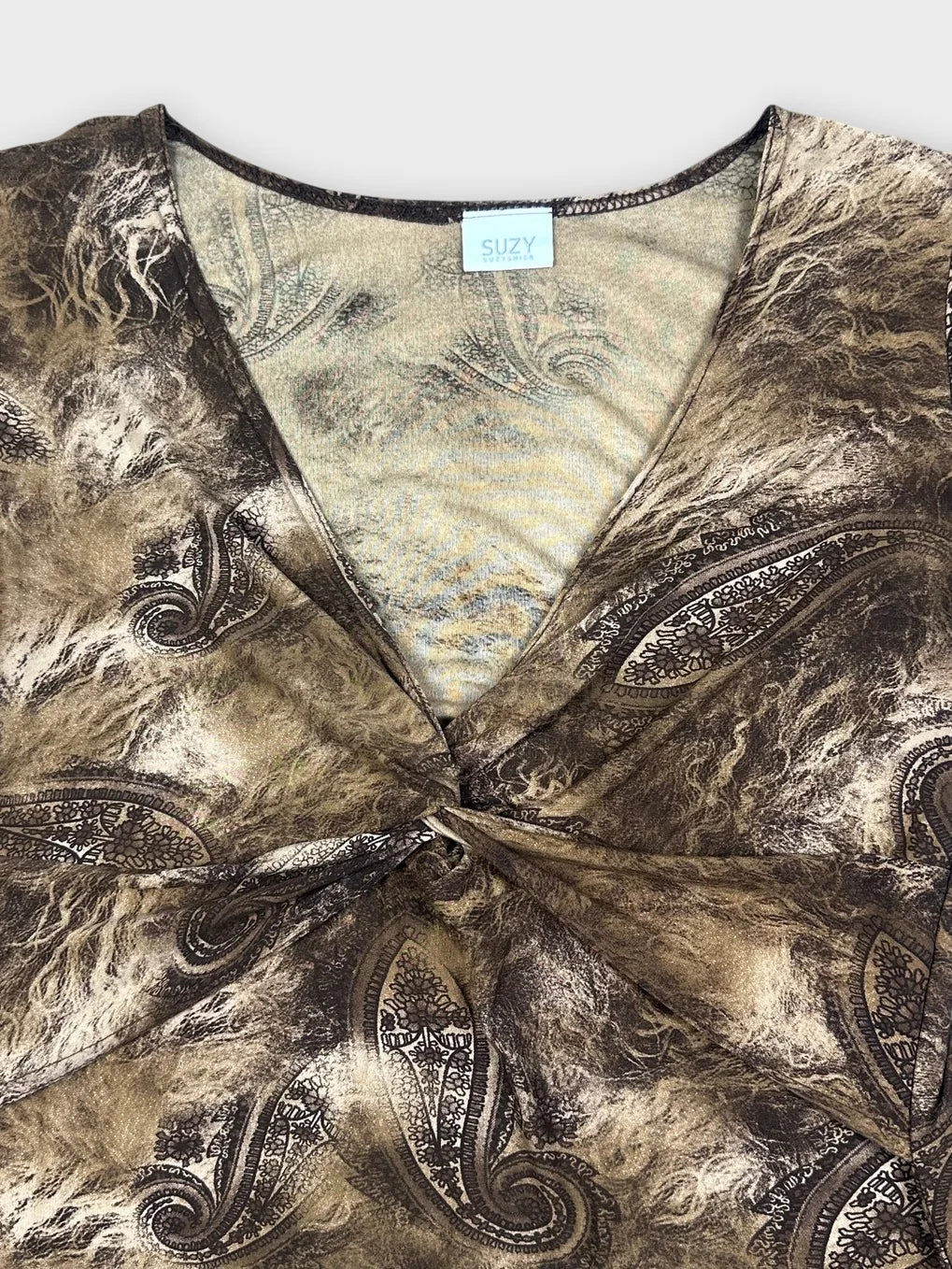 Detail view of a vintage mesh top in brown with paisley pattern.
