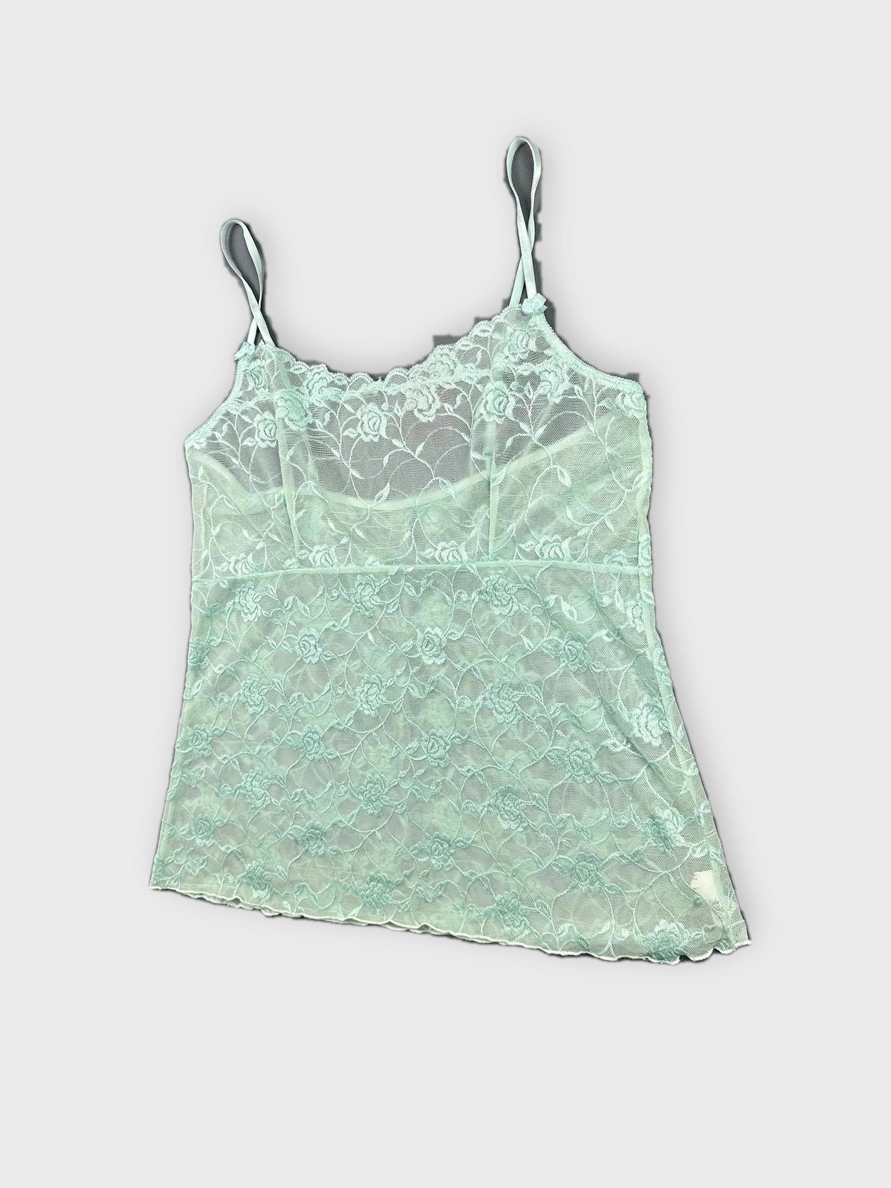 Detail view of mint lace camisole with floral pattern and thin straps.
