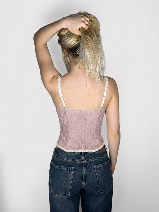Back view of a pink lace crop top with wavy pattern and lace trim.